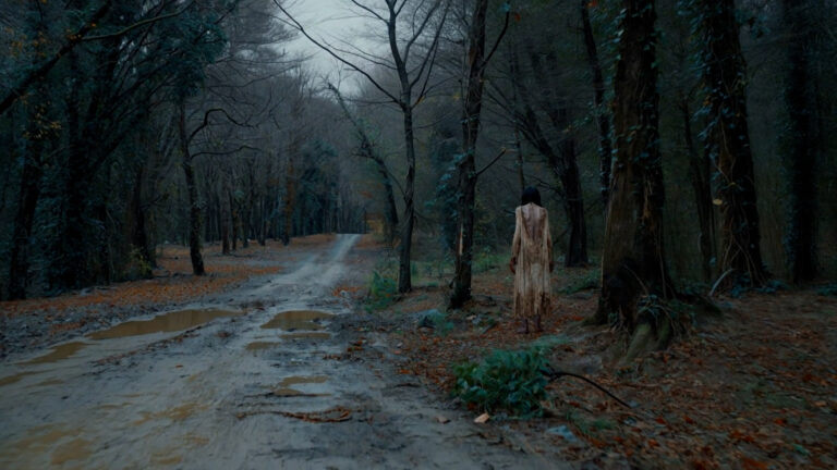 Blair Witch — a figure on a misty forest road, frame from Leopati’s AI horror sequences