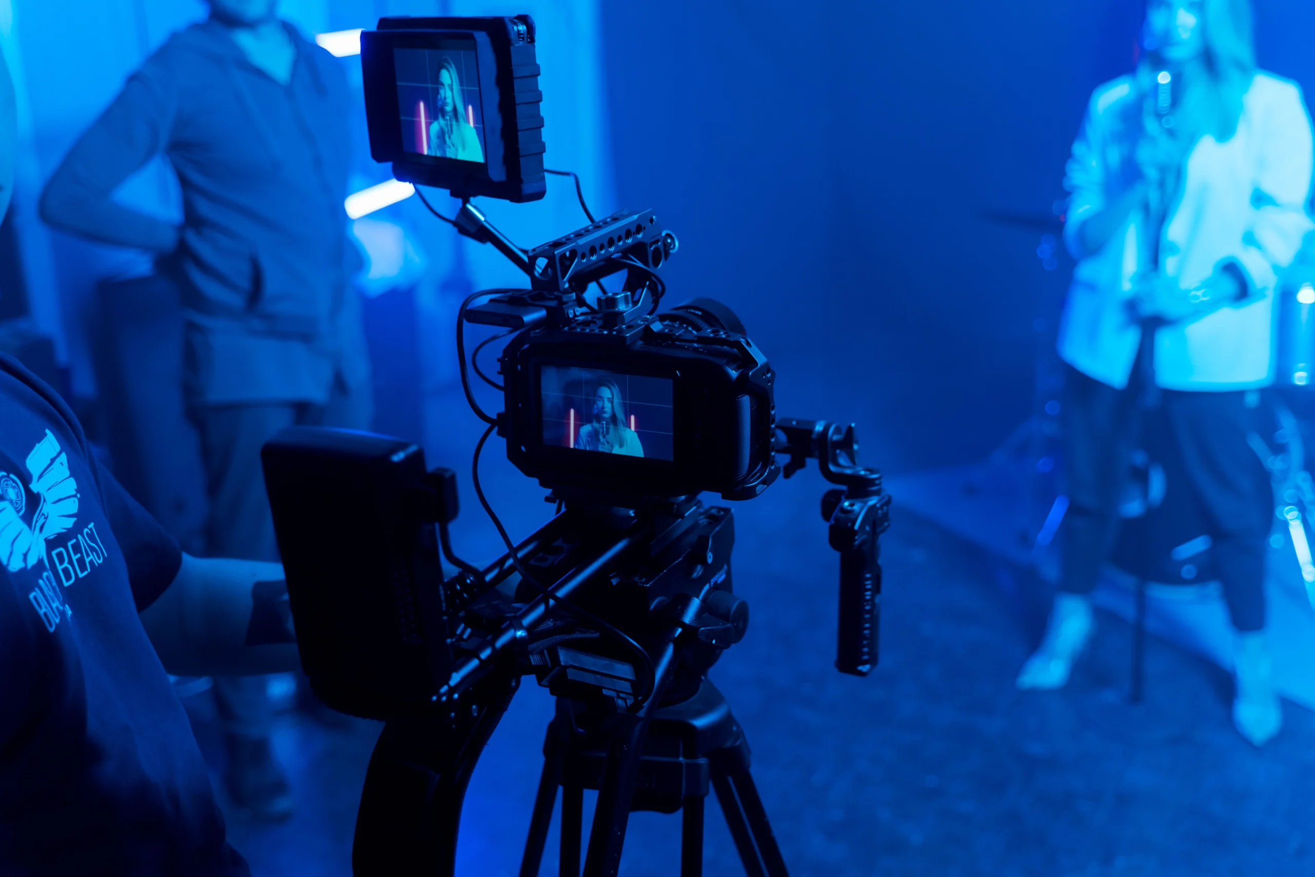 Blue-lit music video set with camera and performer for a dark urban production