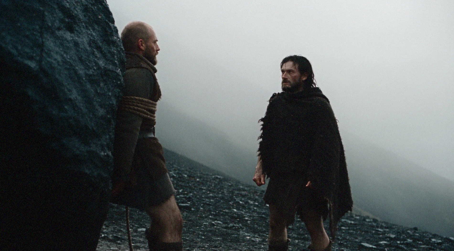 THYMOS confronts another figure within the film’s cold, mist-covered mountain world, where isolation and distance shape every encounter.